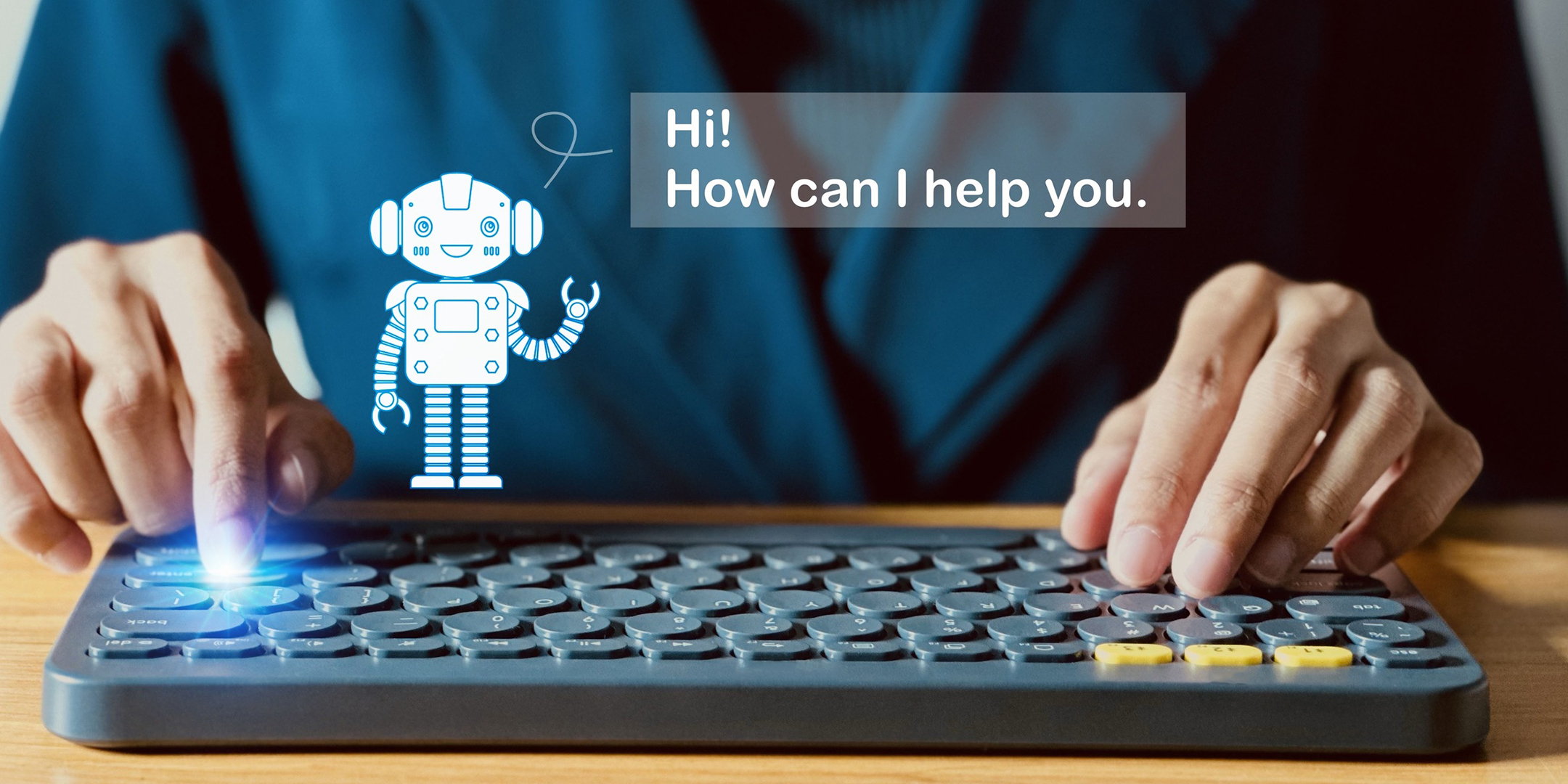 A user in blue clothing typing on a circle-key-styled wireless keyboard, with a spark on the enter button, and a hologram of a robot greeting them, asking them how it can help.